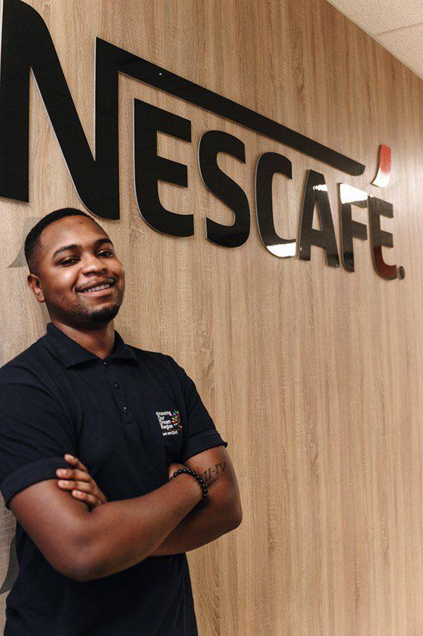 A Nestlé employee beside the Nescafé wall